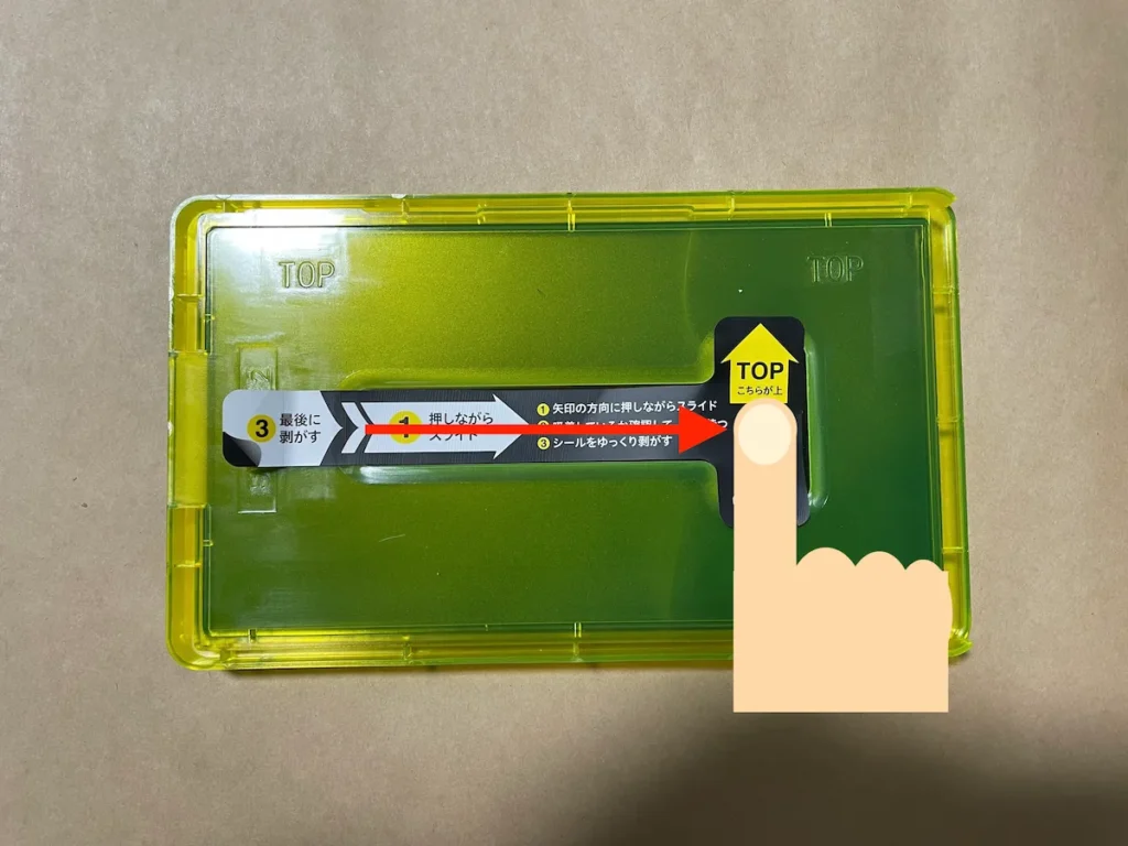 中央のシール上を指で押さえて右へスライドする様子
